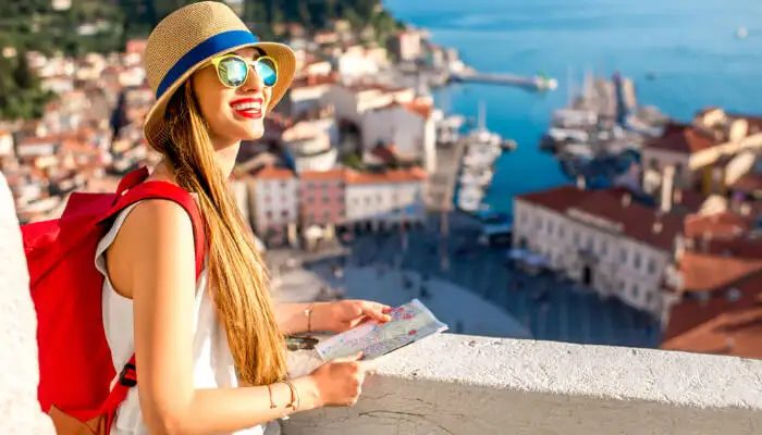 A student traveller overlooking a harbour town on the European coastline